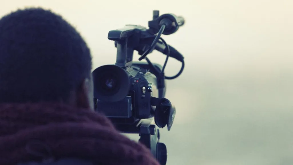 Videomaker filmando com câmera profissional
